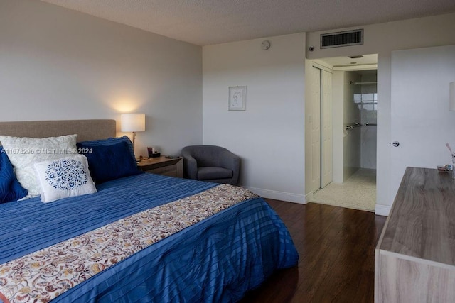 bedroom featuring a textured ceiling, a closet, and dark wood-type flooring