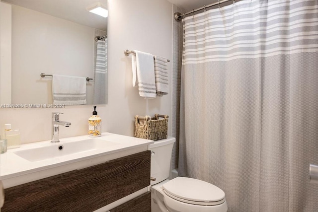 bathroom featuring curtained shower, vanity, and toilet