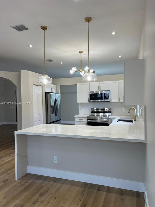 kitchen featuring kitchen peninsula, dark hardwood / wood-style flooring, white cabinetry, sink, and stainless steel appliances