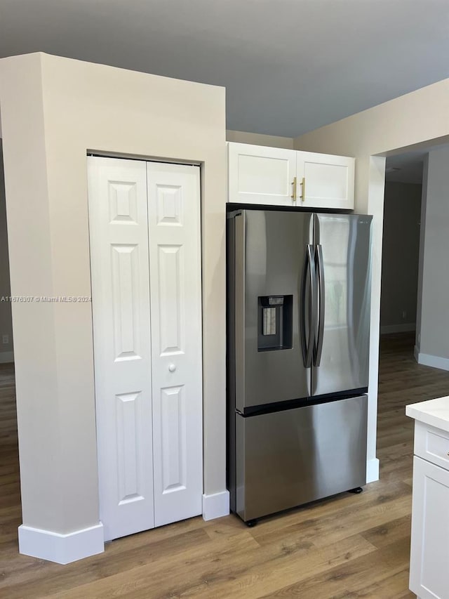 kitchen with white cabinetry, light hardwood / wood-style floors, and stainless steel refrigerator with ice dispenser