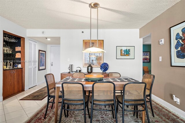 tiled dining room with a textured ceiling