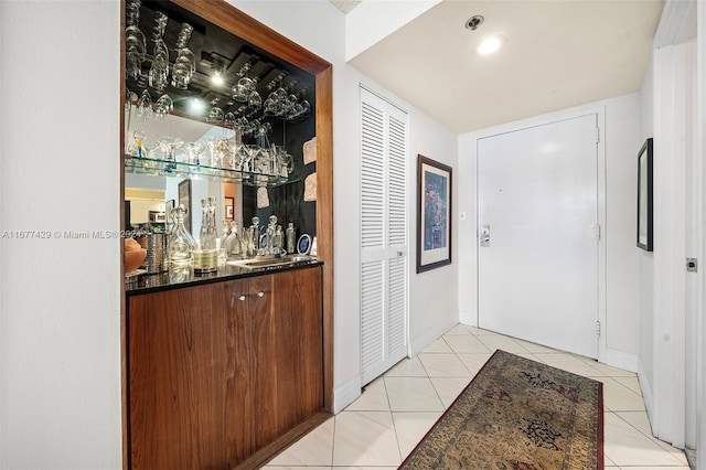 bar with sink and light tile patterned floors