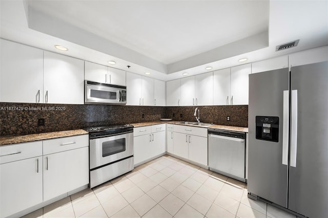 1627 Brickell Ave Unit 1906, Miami, FL 33129 - kitchen with appliances with stainless steel finishes, decorative backsplash, white cabinets, recessed lighting, and dark stone counters