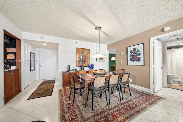 tiled dining area featuring a textured ceiling