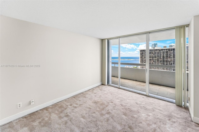 1627 Brickell Ave Unit 1906, Miami, FL 33129 - spare room featuring expansive windows, a water view, and carpet floors