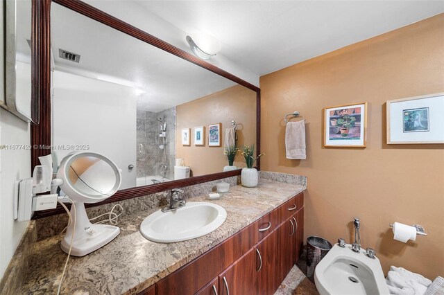 bathroom featuring vanity, a bidet, and tiled shower