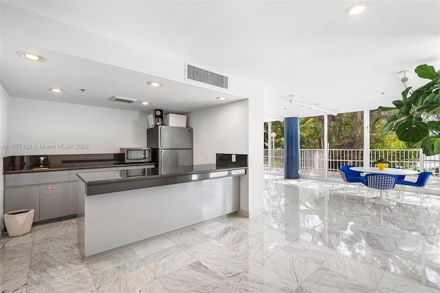 1627 Brickell Ave Unit 1906, Miami, FL 33129 - kitchen with stainless steel appliances, light marble finish floors, recessed lighting, dark countertops, and a peninsula