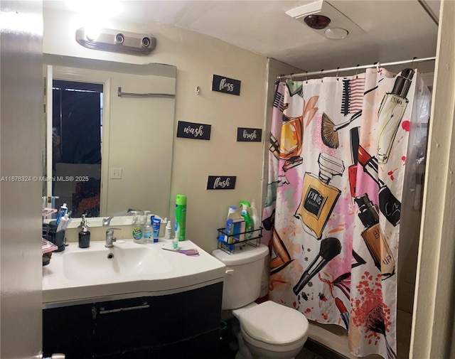 bathroom featuring toilet, vanity, and a shower with curtain