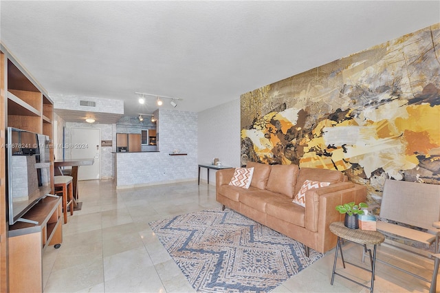 living room with light tile patterned flooring, a textured ceiling, and rail lighting