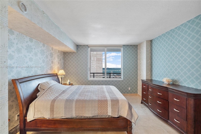 tiled bedroom with a textured ceiling