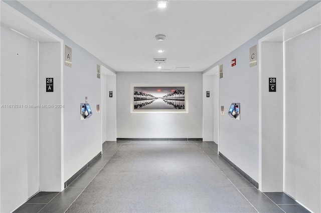 corridor featuring dark tile patterned flooring