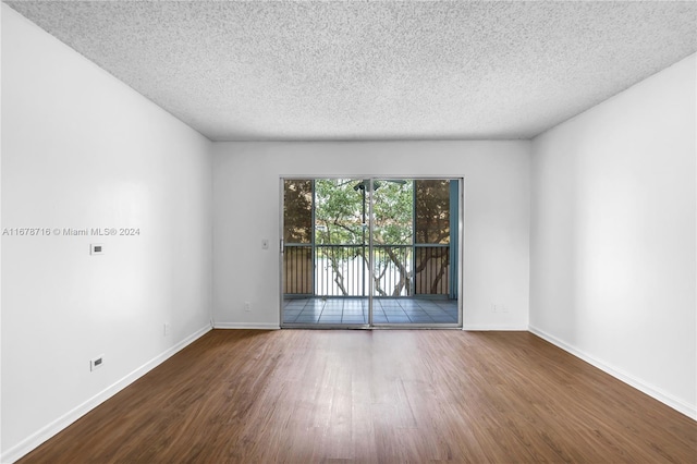 spare room with dark wood-type flooring and a textured ceiling