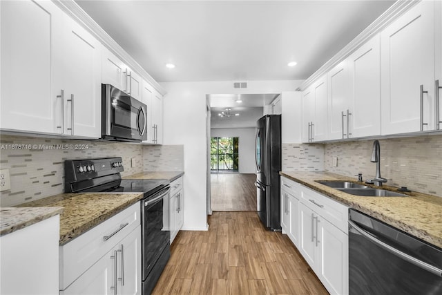 kitchen with sink, appliances with stainless steel finishes, light hardwood / wood-style flooring, and white cabinetry