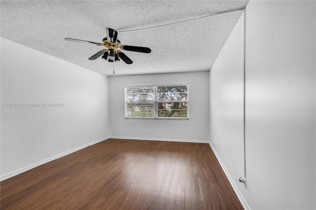 empty room with ceiling fan, a textured ceiling, and dark hardwood / wood-style flooring