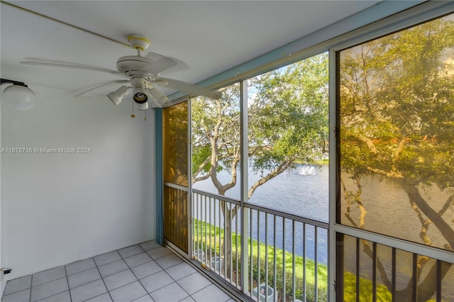 unfurnished sunroom with a water view and ceiling fan