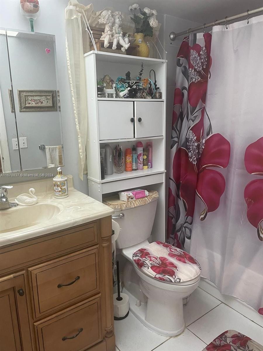 bathroom with vanity, tile patterned floors, toilet, and walk in shower