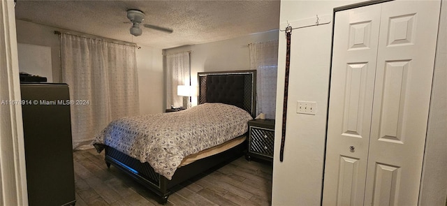 bedroom featuring ceiling fan, wood-type flooring, and a textured ceiling