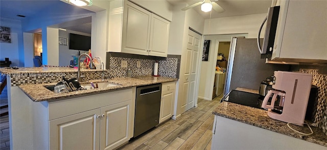 kitchen featuring white cabinets, light wood-type flooring, stone countertops, sink, and stainless steel appliances