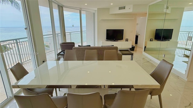 dining space featuring a water view and a beach view