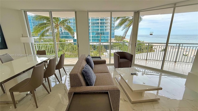 sunroom / solarium with a view of the beach, a water view, and a wealth of natural light