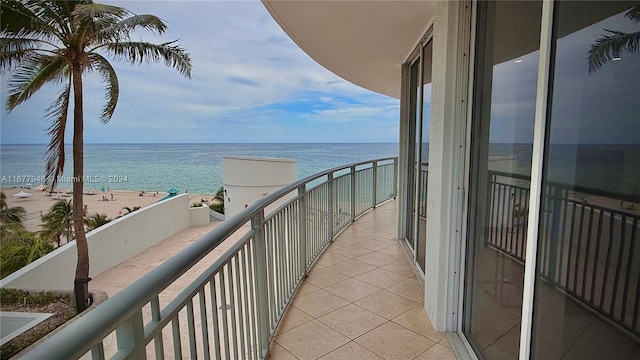 balcony featuring a water view and a beach view