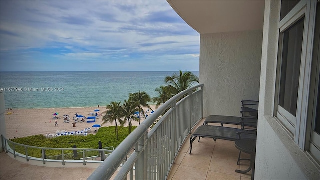 balcony featuring a water view and a beach view