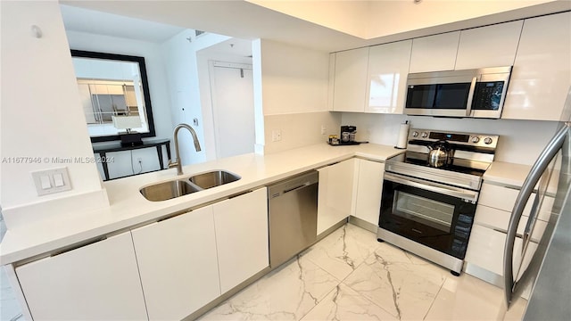 kitchen featuring sink, appliances with stainless steel finishes, and white cabinetry