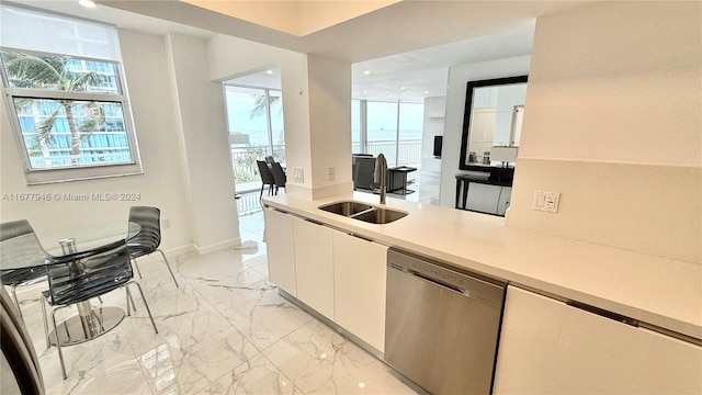 kitchen with sink, dishwasher, and white cabinets