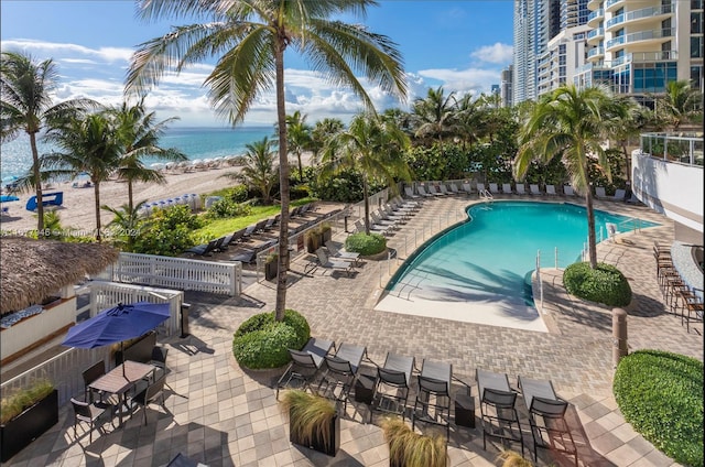 view of pool featuring a patio area and a water view