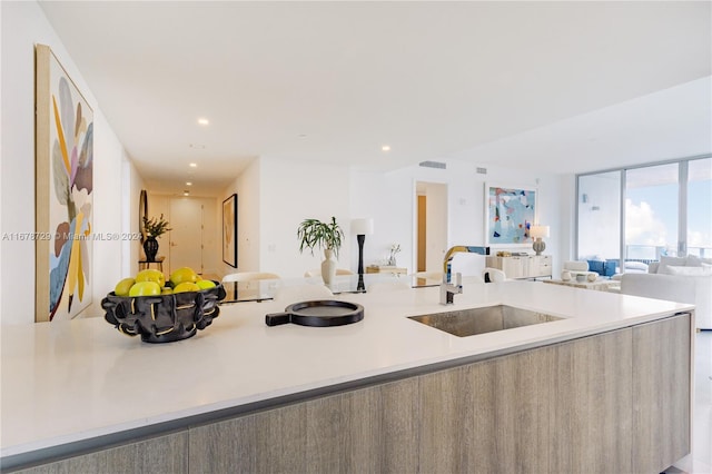 kitchen with black microwave, stainless steel oven, sink, a kitchen bar, and a center island with sink