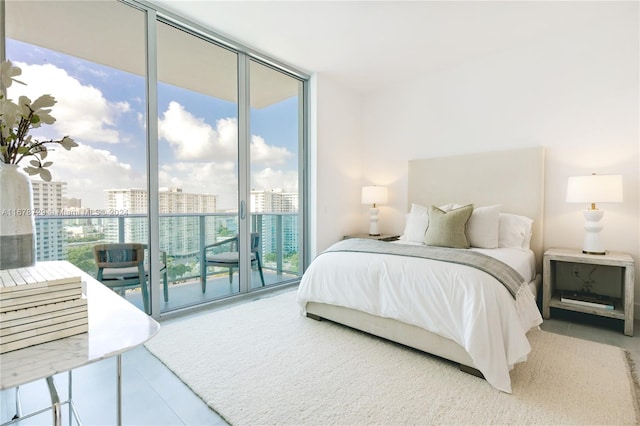 bedroom with access to exterior, a wall of windows, and multiple windows