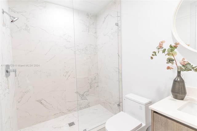 bathroom featuring vanity, toilet, and tiled shower