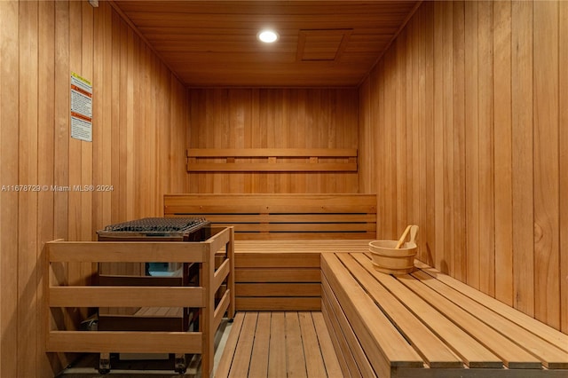 view of sauna featuring wood ceiling, wooden walls, and wood-type flooring