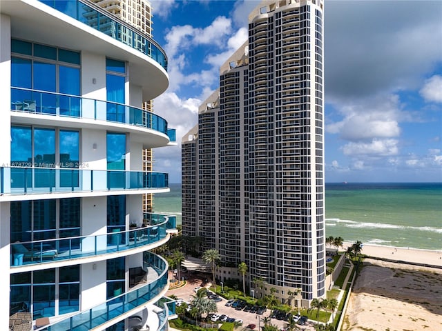 view of property with a water view and a view of the beach