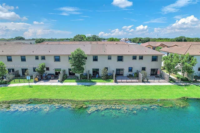 rear view of property featuring a patio area, a water view, and a yard