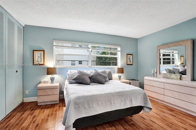 bedroom featuring a closet, hardwood / wood-style floors, and a textured ceiling