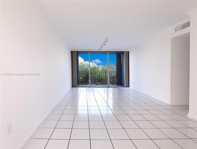 unfurnished room featuring a wall of windows and light tile patterned floors