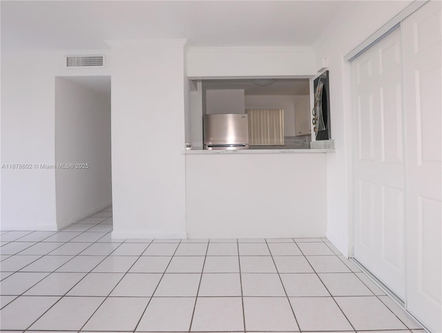 unfurnished room with light tile patterned floors and ornamental molding