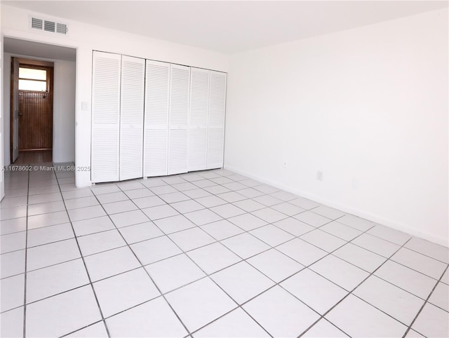 unfurnished bedroom with a closet and light tile patterned floors