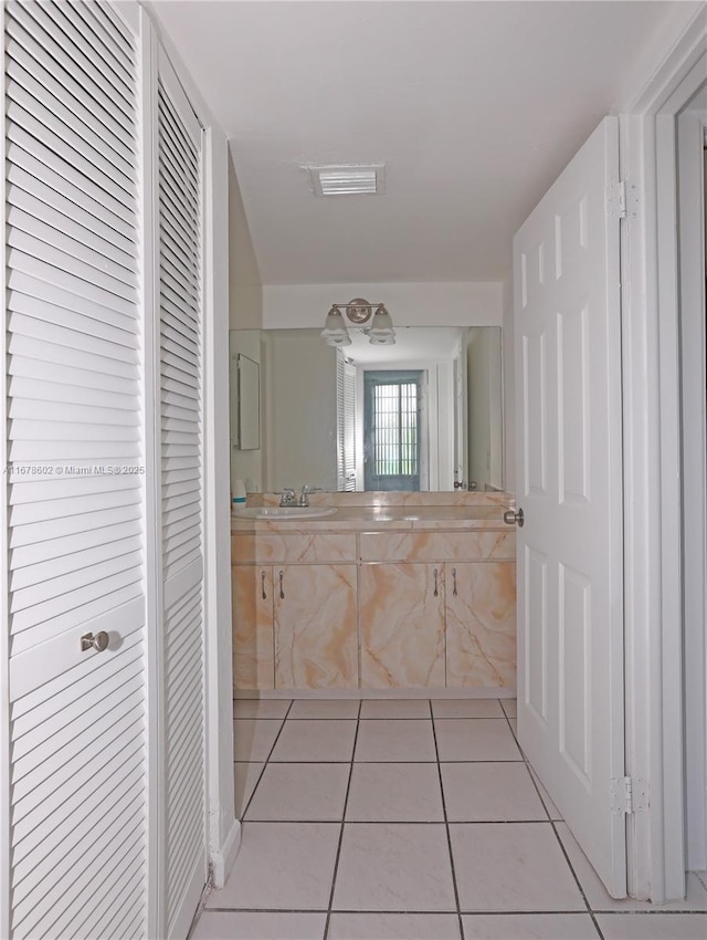 corridor with sink and light tile patterned flooring