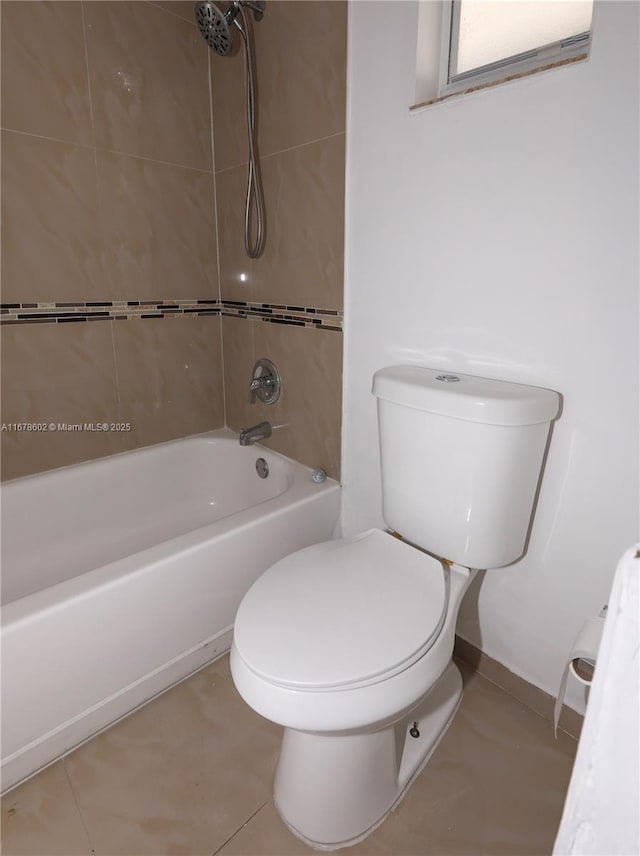 bathroom featuring toilet, tiled shower / bath, and tile patterned flooring