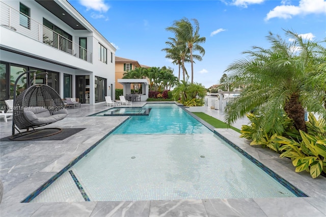 view of pool featuring a patio area and an in ground hot tub