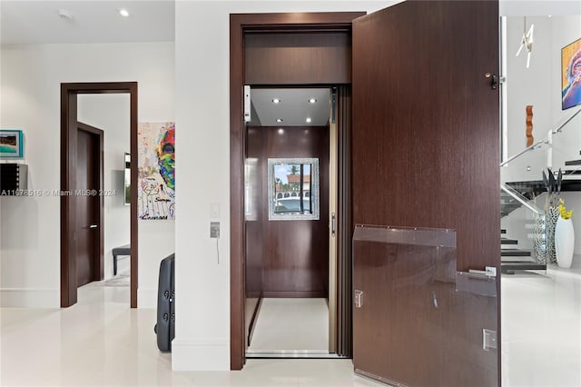 hallway with light tile patterned floors and elevator