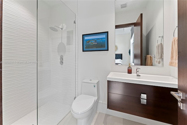 bathroom featuring vanity, toilet, and tiled shower