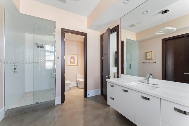 bathroom with vanity, toilet, a bidet, and a shower with shower door