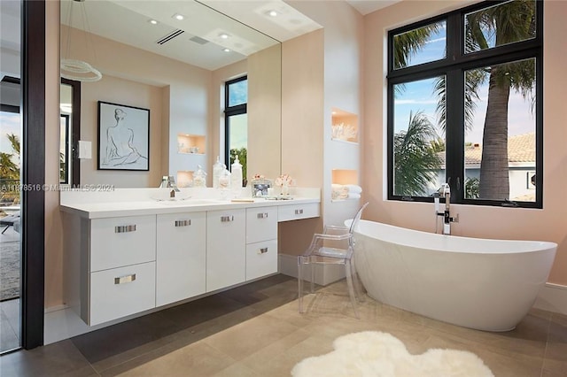 bathroom featuring vanity, tile patterned flooring, and a bathing tub