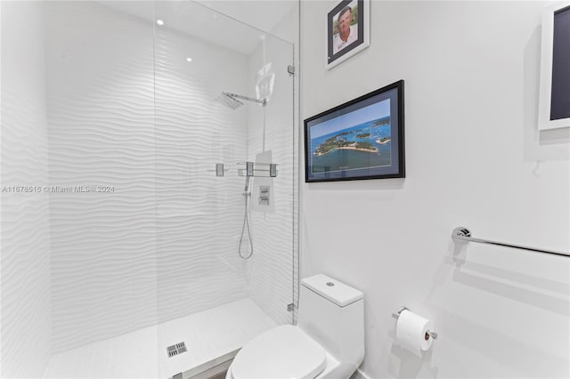 bathroom featuring toilet and an enclosed shower