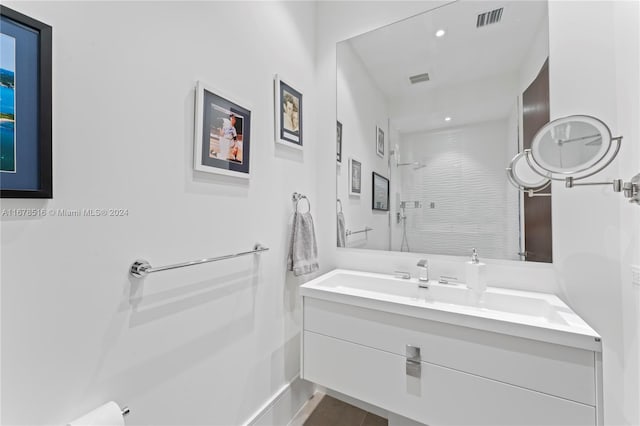 bathroom featuring vanity and tiled shower