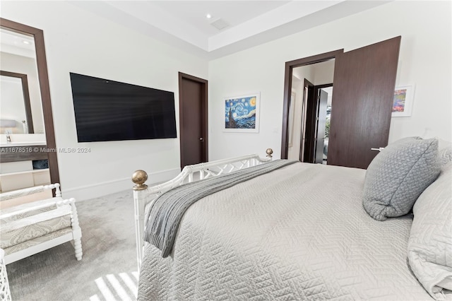 bedroom with ensuite bathroom and carpet