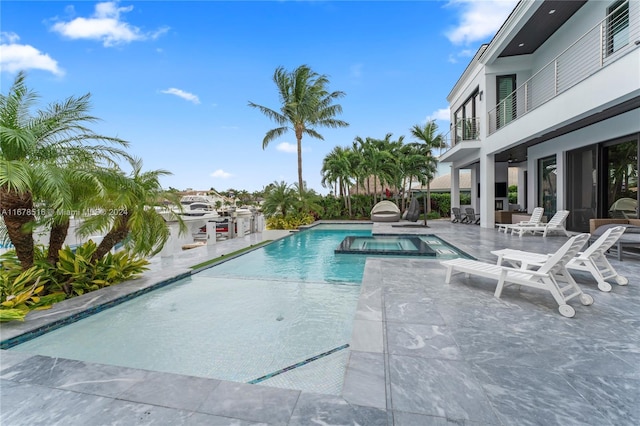 view of swimming pool featuring an in ground hot tub and a patio area